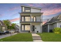 Modern two-story home with a well-manicured lawn, gray and white siding, and a second-story balcony at 704 Parkway Ave, Indianapolis, IN 46203