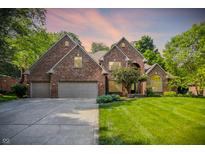 Charming brick home boasts a manicured lawn, mature trees, and a three-car garage, perfect for Gathering living at 7648 W Williamswood Dr, New Palestine, IN 46163
