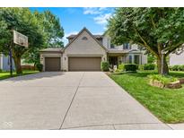Charming two-story home featuring a spacious driveway, well-maintained lawn, and a three-car garage at 12043 Searay Dr, Indianapolis, IN 46236