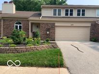 Brick front exterior featuring a two-car garage, well-kept lawn and tasteful landscaping at 1419 Dominion Dr, Zionsville, IN 46077