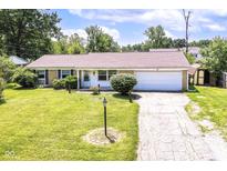 Charming single-story home with a brick facade, well-maintained lawn, and attached two car garage at 1543 W 79Th St, Indianapolis, IN 46260