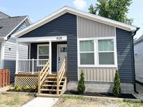 Charming home showcasing dark blue and tan siding and a quaint porch with white railings and wooden stairs at 1628 Spann Ave, Indianapolis, IN 46203