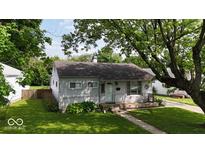 Charming single-story home with a well-maintained lawn and mature trees providing shade at 1837 Bauer Rd, Indianapolis, IN 46218