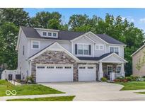 Charming two-story home with stone accents, a two-car garage, a beautifully landscaped yard, and an inviting front porch at 210 Lynnette Way, Cumberland, IN 46229