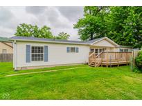 Charming single-story home featuring blue shutters, a small deck, and a well-manicured lawn at 3149 Carson Ave, Indianapolis, IN 46227