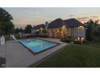 Gorgeous backyard with a luxurious pool, slide, patio, and outdoor fireplace for elegant entertaining at 3795 Claybrook Ct, Bargersville, IN 46106