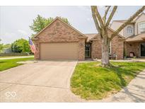 Charming brick home featuring an attached two-car garage and a well-manicured front lawn at 4420 Victory Blvd, Indianapolis, IN 46203