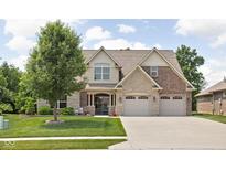 Charming two-story home featuring a manicured lawn, mature tree, and a blend of brick and stone accents at 5194 Orahood Ct, Plainfield, IN 46168