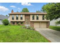Charming two-story home with brick and siding, attached two car garage, and well-maintained lawn at 5847 Democracy Dr, Indianapolis, IN 46254