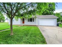Charming single-story home features a well-manicured lawn, attached garage, and inviting front porch at 6616 S Cross St, Pendleton, IN 46064