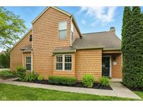 Inviting two-story home featuring cedar shake siding, well-maintained landscaping, and a charming entrance at 7414 Harbour, Indianapolis, IN 46240