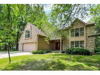 Charming two-story home with a brick facade, attached garage, and a well-maintained lawn at 7720 Langwood Dr, Indianapolis, IN 46268