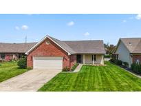 Charming brick home with a well-manicured lawn and attached two-car garage at 10938 E Mount Vernon N Trl, Indianapolis, IN 46229