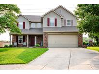 Charming two-story home with a well-manicured lawn, brick accents, and a two-car garage at 1242 Flatrock Dr, Anderson, IN 46013