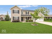Charming two-story home featuring a well-manicured lawn, attached garage, and a welcoming front porch at 12845 Touchdown Dr, Fishers, IN 46037