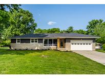 Charming single-story home featuring a well-maintained lawn and stone accents at 130 N High School Rd, Indianapolis, IN 46214