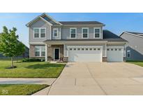Traditional two-story home with gray siding, brick accents, well-manicured lawn, and a three-car garage at 15736 Conductors Dr, Westfield, IN 46074