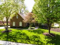 Charming brick home featuring a manicured lawn and mature shade trees at 16307 Stony Ridge Dr, Noblesville, IN 46060