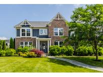 Charming two-story brick home with a well-manicured lawn and lush landscaping at 16310 Nightshore Ln, Fishers, IN 46037