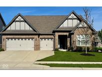 Beautiful brick home featuring a three-car garage and manicured lawn at 17324 Americana Crossing Xing, Noblesville, IN 46060