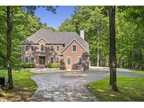 Stately brick home with a circular driveway, surrounded by manicured landscaping and mature trees at 2034 Dynasty Ridge Rd, Martinsville, IN 46151