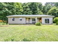 Charming single-story home with a metal roof, covered porch, and partially wooded front yard at 2246 E Yellowwood Ln, Martinsville, IN 46151