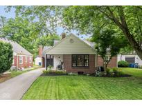 Charming brick home featuring a well-manicured lawn and beautiful landscaping, perfect for curb appeal at 253 W Westfield Blvd, Indianapolis, IN 46208