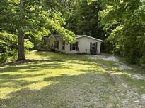 Charming single-story home with a well-maintained lawn and surrounded by mature trees at 3042 S Conservation Club Rd, Morgantown, IN 46160