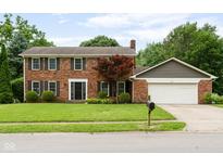 Charming brick home featuring a two-car garage and a well-maintained front yard with mature trees at 3439 Eden Park Dr, Carmel, IN 46033