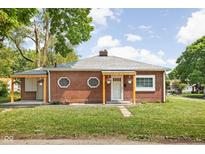 Charming brick home featuring a cozy porch with hanging flower baskets at 4502 Evanston Ave, Indianapolis, IN 46205