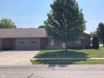 Charming single-story home with an attached two-car garage, brick exterior, and mature landscaping at 4910 Bowie Dr, Anderson, IN 46013