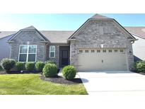 Charming gray brick home with a two-car garage, well-manicured lawn, and beautiful landscaping at 5103 Covington Ave, McCordsville, IN 46055