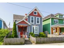 Charming two-story home featuring a colorful exterior, well-maintained lawn, and inviting front porch at 525 Orange St, Indianapolis, IN 46203
