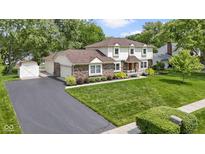 Charming two-story home with brick accents, lush lawn, and attached two car garage at 59 Sycamore Dr, Carmel, IN 46033