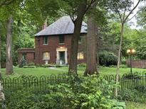 Beautiful brick home with lush lawn, mature trees and slate roof at 6125 N Olney St, Indianapolis, IN 46220