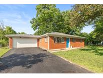 Charming single-story brick home with a vibrant blue front door and attached two-car garage at 7139 Buick Dr, Indianapolis, IN 46214