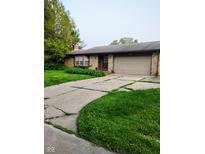 Brick single-story house with an attached two-car garage and a concrete driveway at 721 Maplewood Ave, Anderson, IN 46012