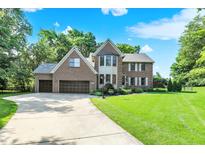Charming two-story brick home with an attached garage and beautifully landscaped front yard at 8261 Twin Pointe Cir, Indianapolis, IN 46236