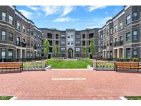 Beautiful courtyard featuring well-manicured lawns, benches and walkways surrounded by brick apartment buildings at 920 Veterans Way # 204, Carmel, IN 46032