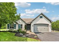 Charming white brick home featuring a two-car garage, lush landscaping, and welcoming curb appeal at 10444 Indian Lake N Blvd, Indianapolis, IN 46236