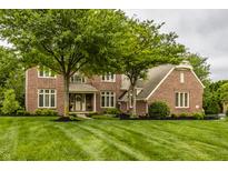 Lovely two-story brick home featuring manicured lawn and mature trees in a peaceful neighborhood setting at 11875 Durbin Dr, Carmel, IN 46032