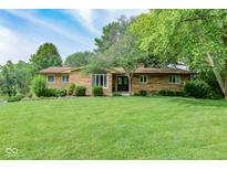 Charming single-story home with stone facade and a well-maintained lawn and mature trees at 138 Plaza Chica St, Greenwood, IN 46143