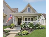Charming home featuring a welcoming front porch, decorative plants, and an American flag at 1623 Hoyt Ave, Indianapolis, IN 46203