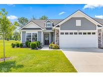 Charming home featuring a two-car garage, beautifully landscaped lawn, and classic gray siding under a clear sky at 19387 Astoria Ave, Sheridan, IN 46069