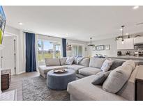Comfortable living room with large windows, gray sectional, and open access to the kitchen at 19387 Astoria Ave, Sheridan, IN 46069