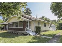 Quaint home featuring a screened-in porch, cream siding and a detached garage at 2245 N Ritter Ave, Indianapolis, IN 46218
