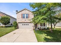 Charming two-story brick home with a well-maintained lawn and attached two-car garage at 2426 Autumn Rd, Indianapolis, IN 46229