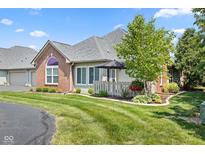 Charming brick home with well-manicured lawn, lush landscaping, and inviting outdoor space at 2717 Reflection Way, Greenwood, IN 46143
