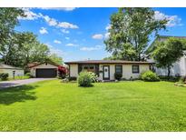 Charming home featuring lush green lawn and a detached garage at 4770 Willow Rd, Zionsville, IN 46077