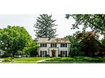 Charming two-story home with a brick facade, manicured lawn, and mature trees at 5261 N Pennsylvania St, Indianapolis, IN 46220